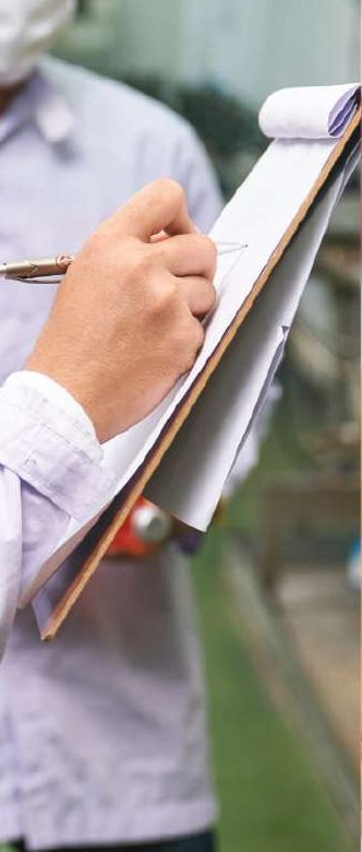 Quality inspector recording checks with a clipboard